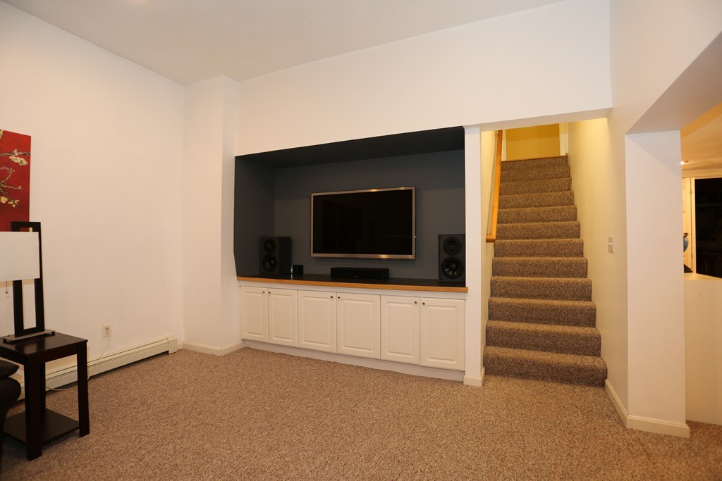 2 Woodside Road Framingham, MA 01701 - Photo 22 of 29 a living room with a flat screen tv a rug and a window