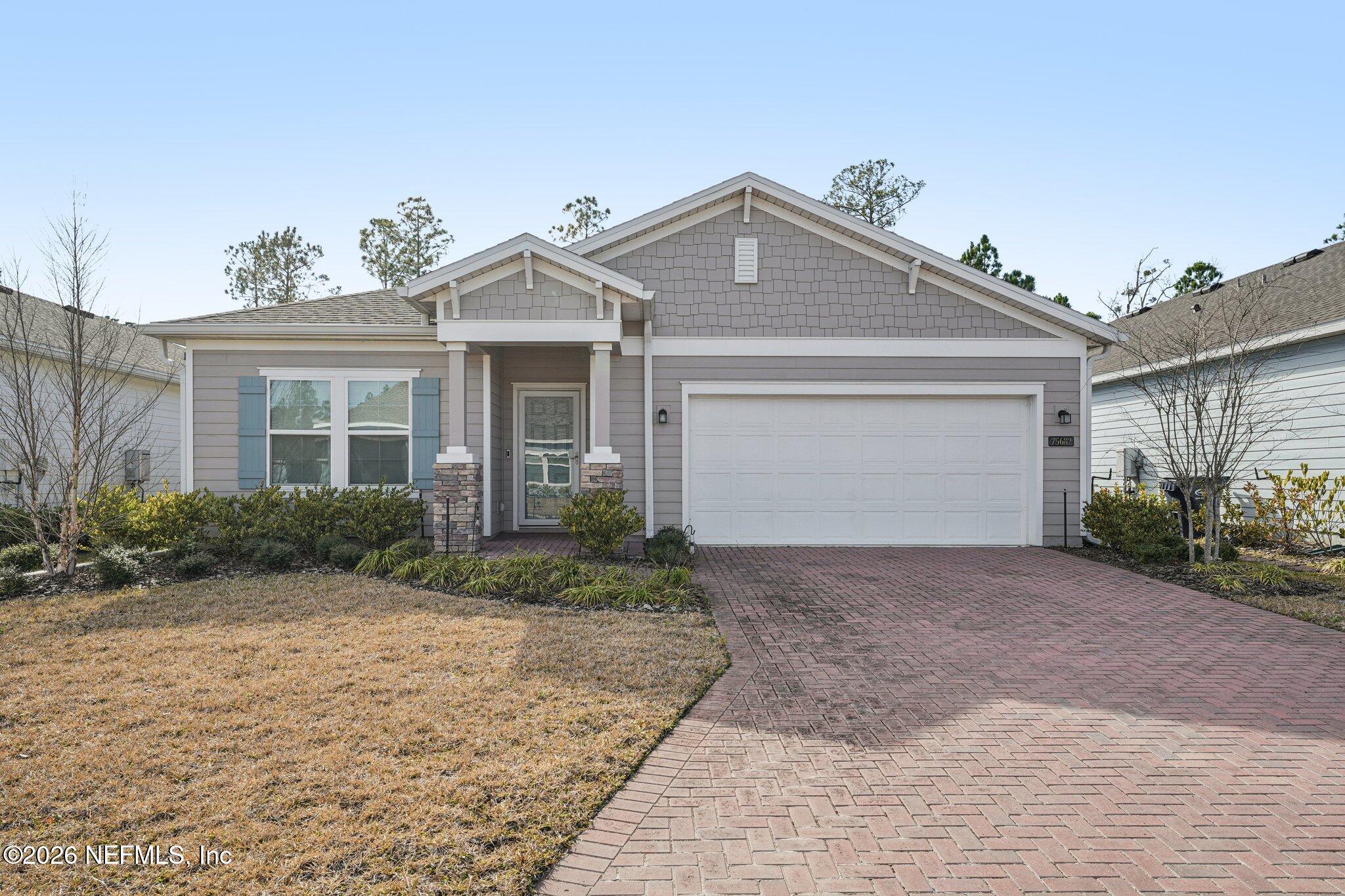 75682 Pondside Lane Yulee, FL 32097 - Photo 1 of 35 a front view of a house with garden