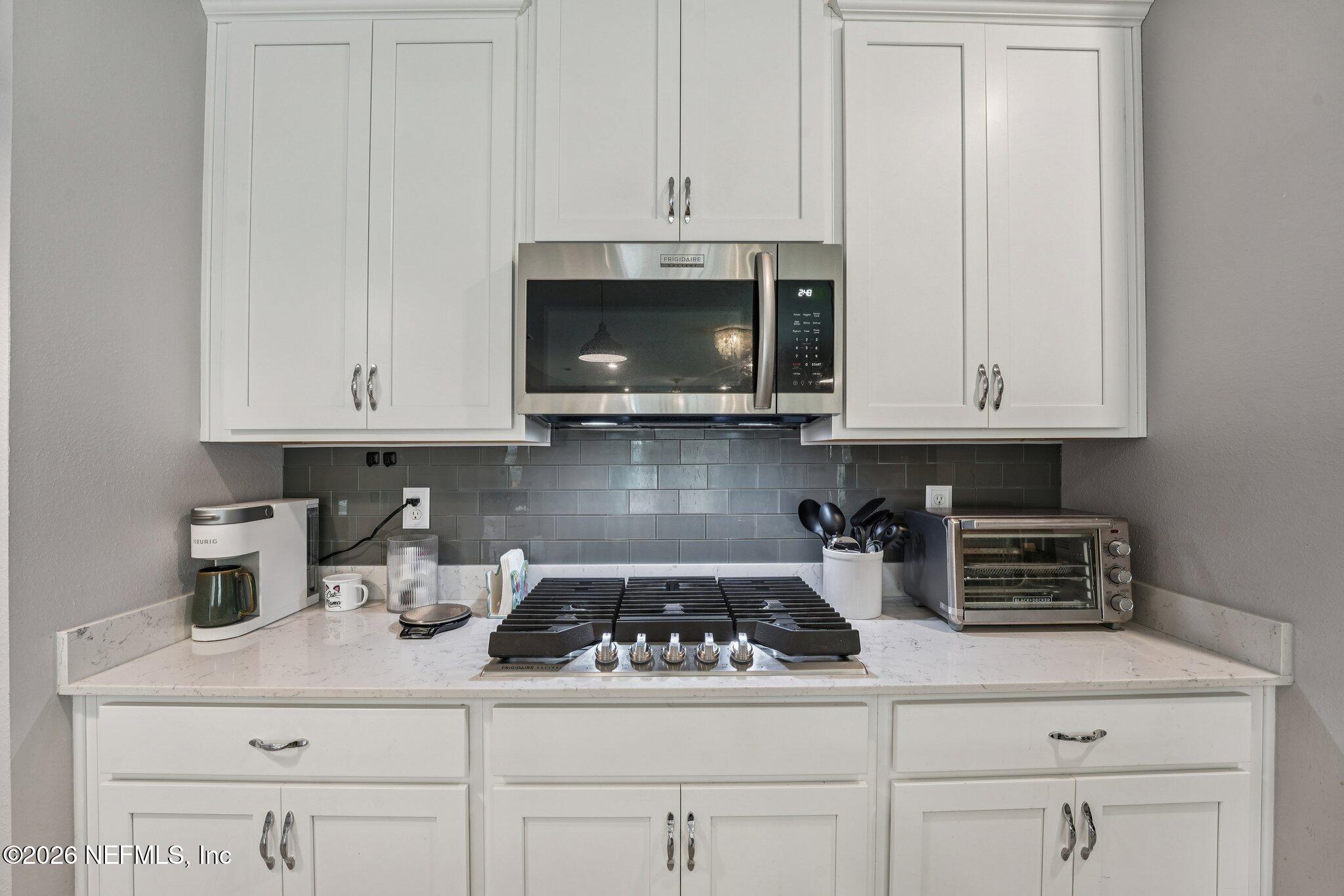75682 Pondside Lane Yulee, FL 32097 - Photo 12 of 35 a kitchen with white cabinets and appliances