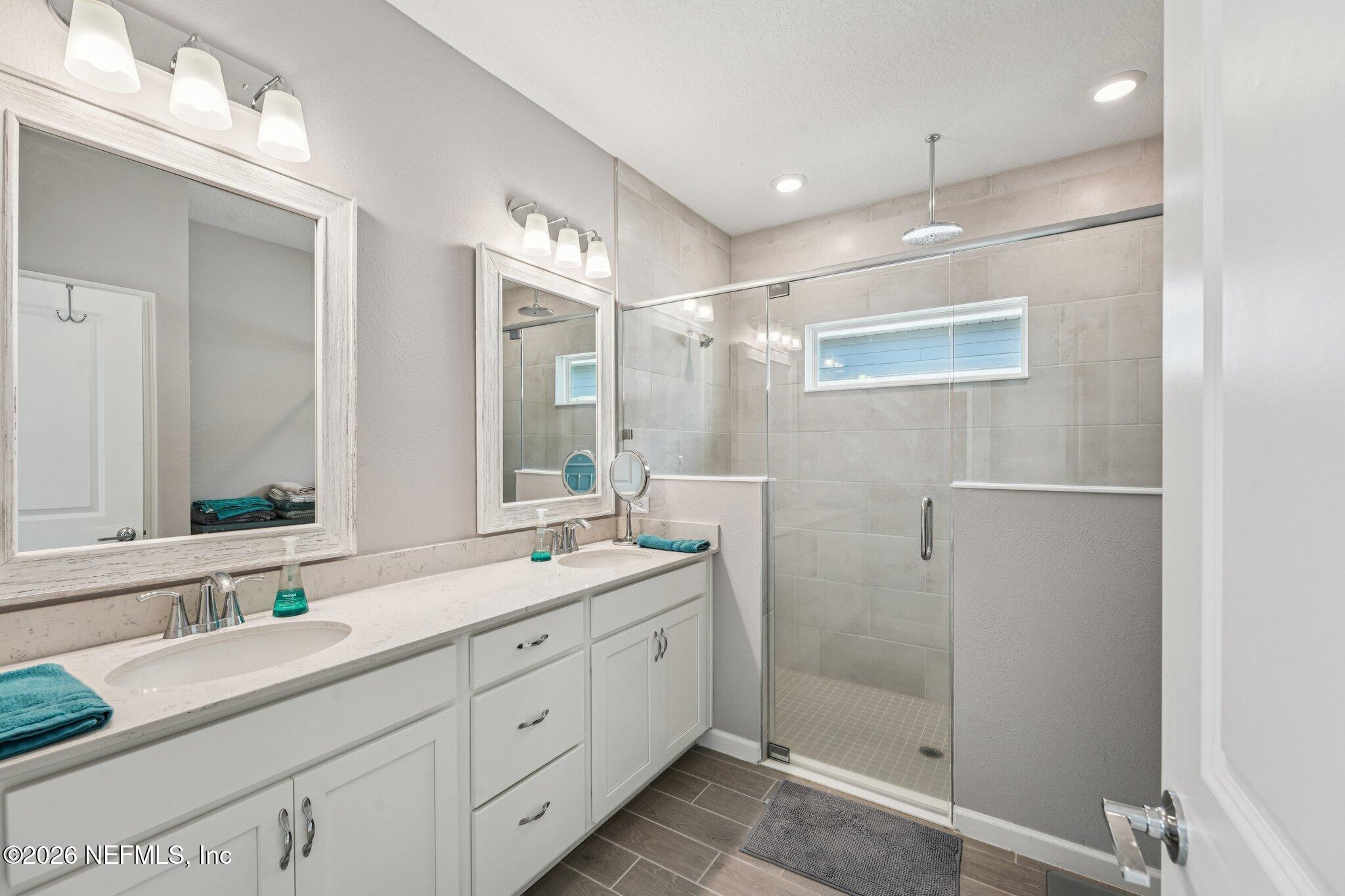 75682 Pondside Lane Yulee, FL 32097 - Photo 18 of 35 a bathroom with a double vanity sink mirror double and shower