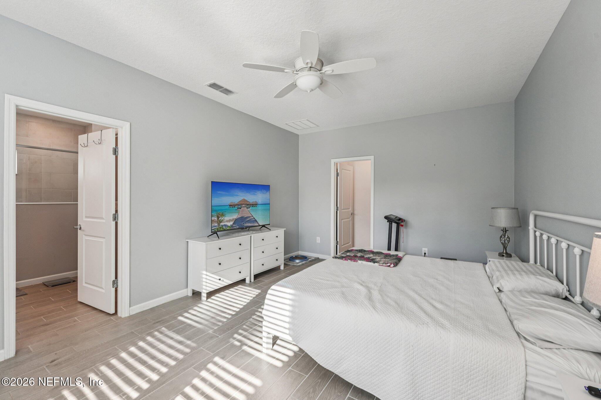 75682 Pondside Lane Yulee, FL 32097 - Photo 21 of 35 a bedroom with a large bed and a chandelier