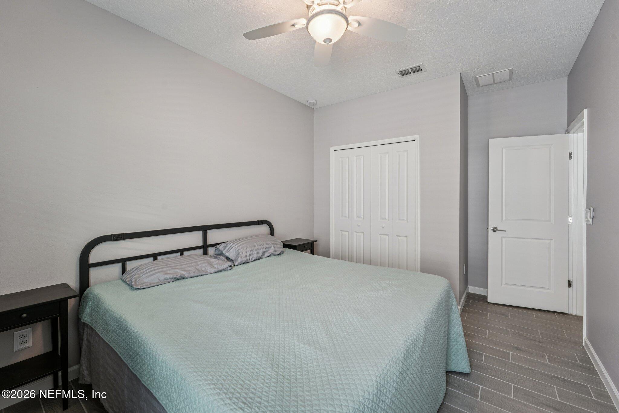 75682 Pondside Lane Yulee, FL 32097 - Photo 26 of 35 a bedroom with a bed and a chandelier