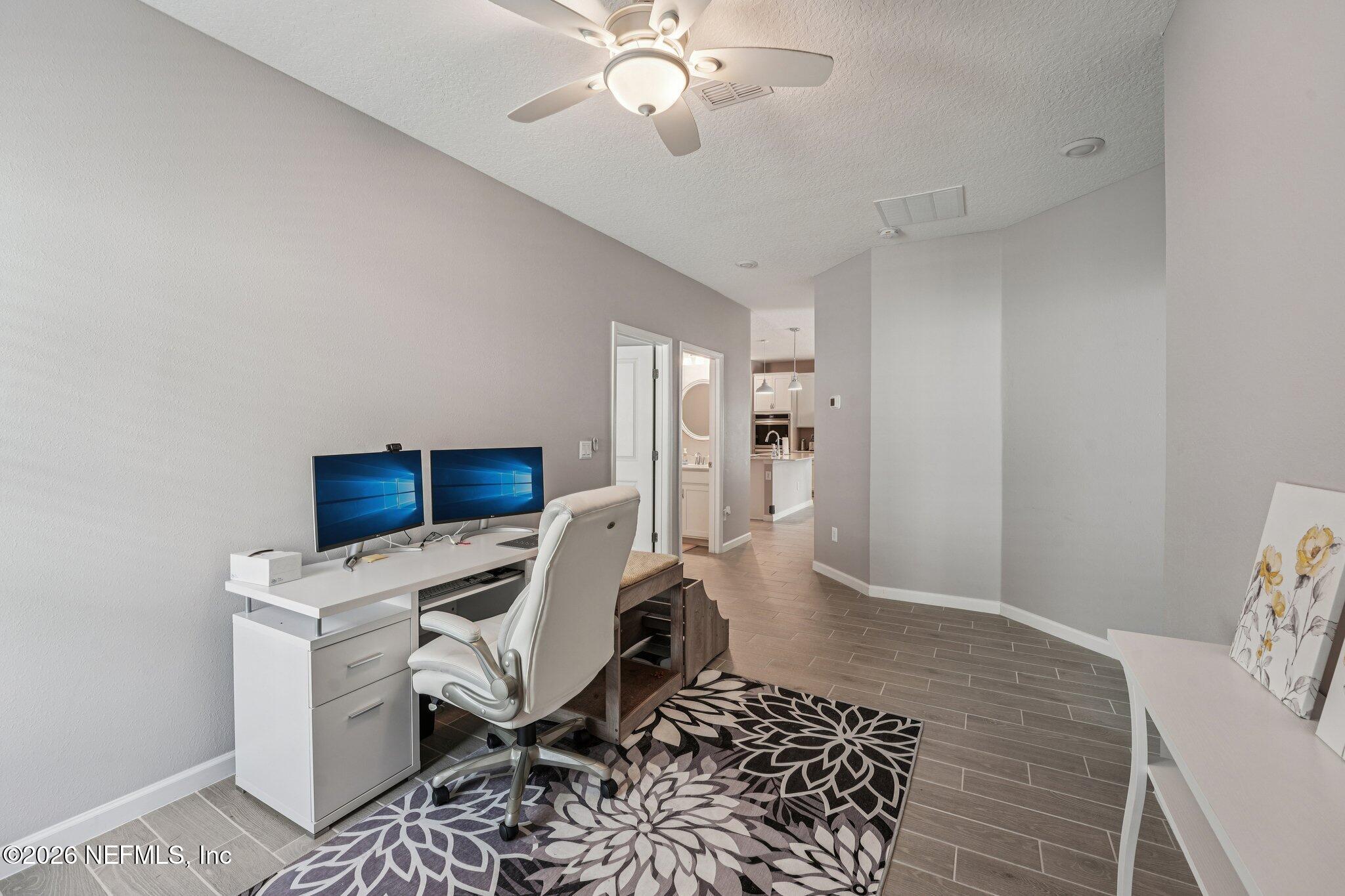 75682 Pondside Lane Yulee, FL 32097 - Photo 28 of 35 a workspace with furniture and chandelier