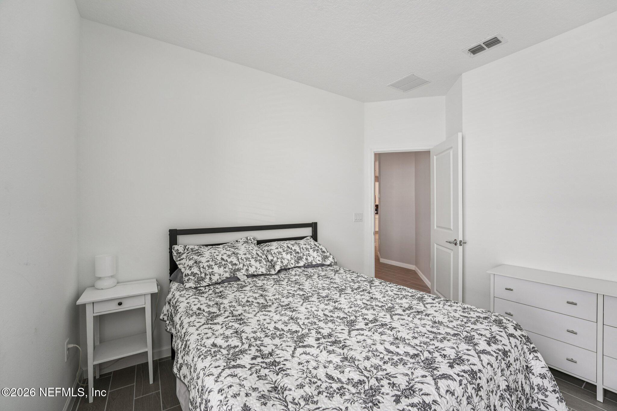 75682 Pondside Lane Yulee, FL 32097 - Photo 30 of 35 a bedroom with a bed and a table