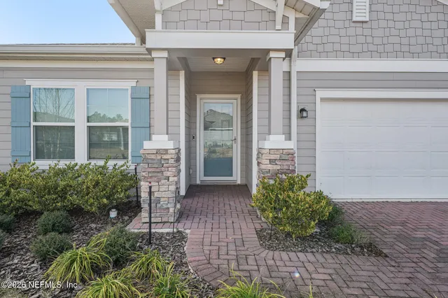 front view of a brick house with potted plants