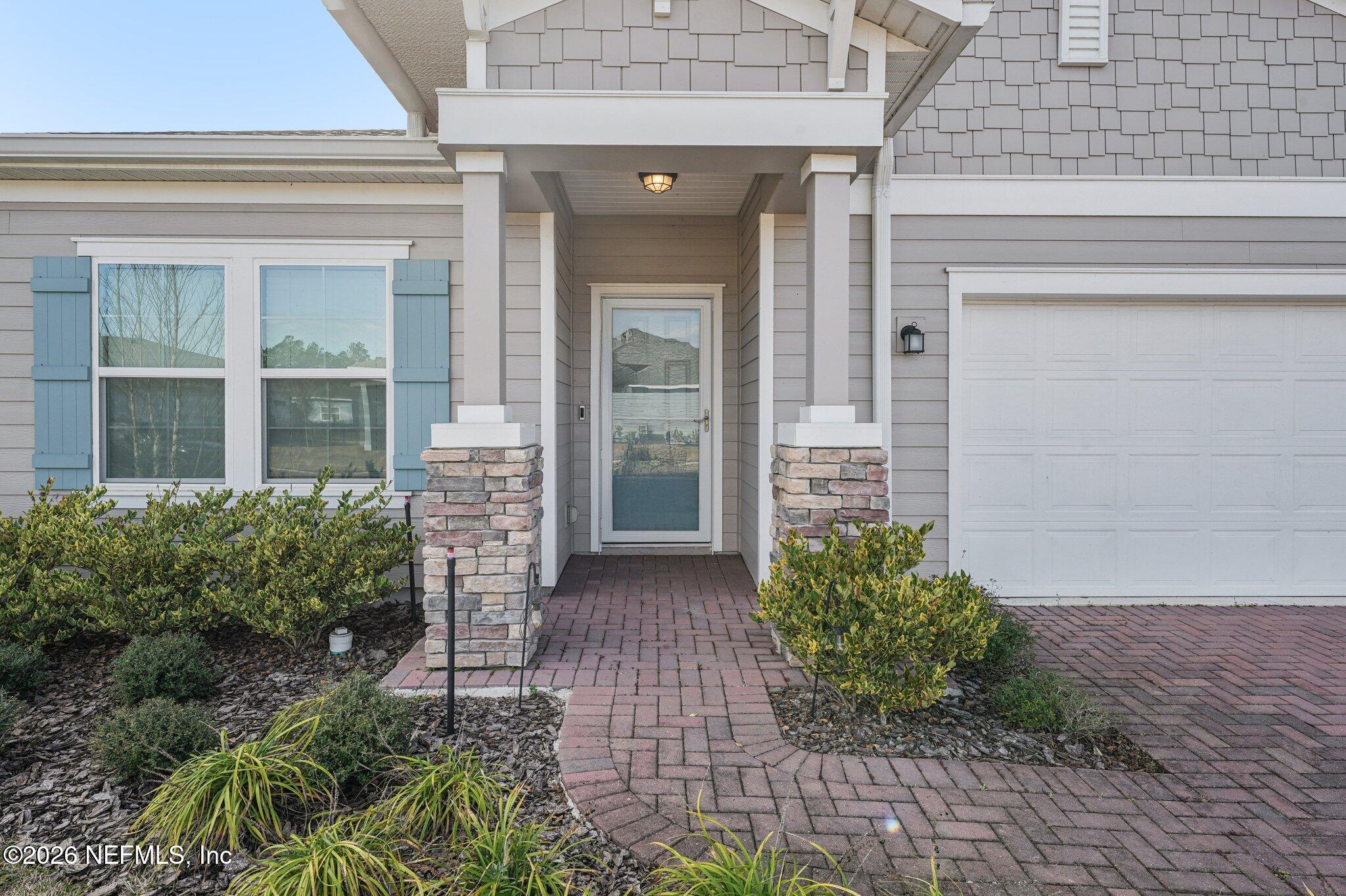 75682 Pondside Lane Yulee, FL 32097 - Photo 4 of 35 front view of a brick house with potted plants