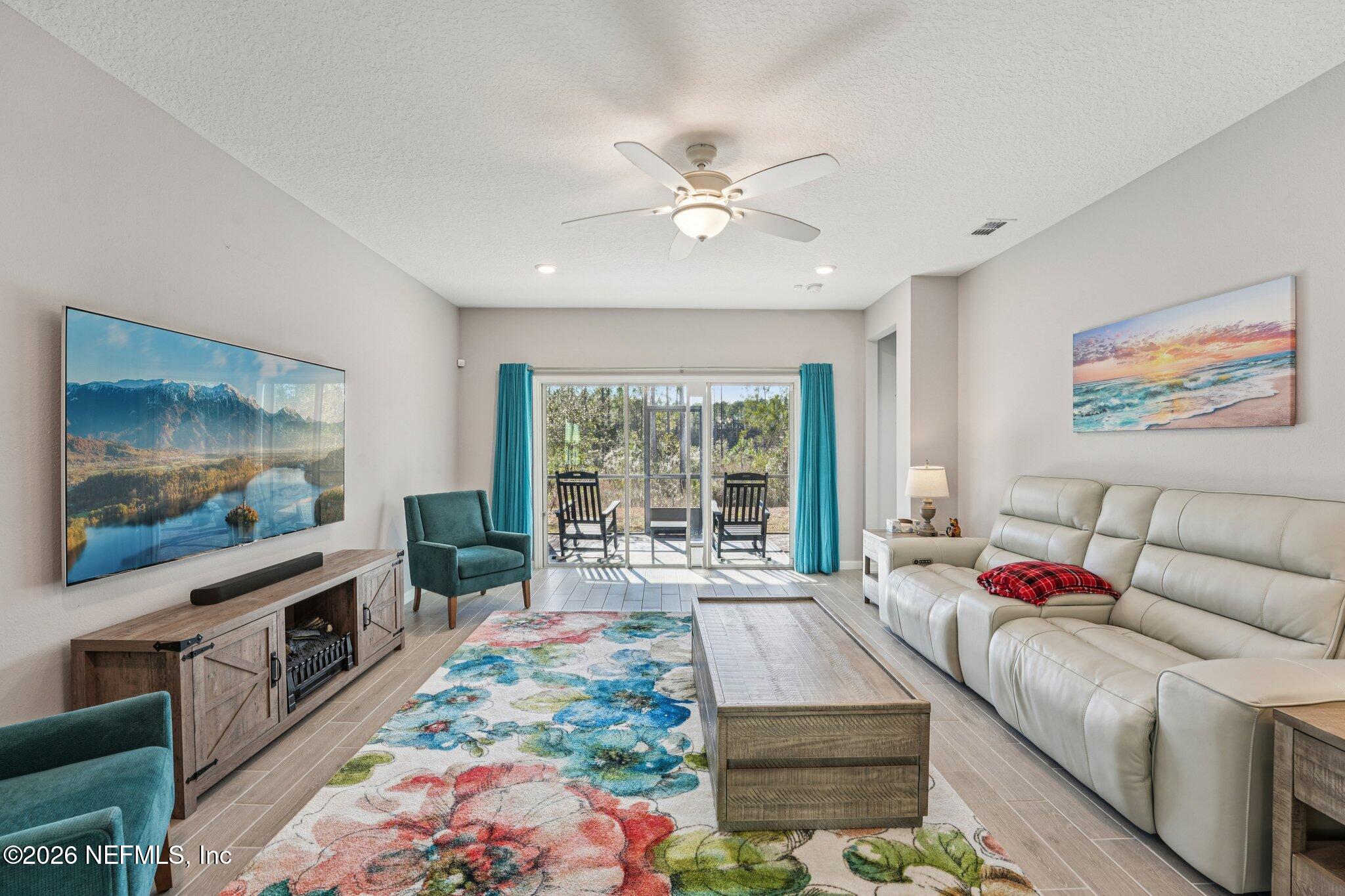 75682 Pondside Lane Yulee, FL 32097 - Photo 6 of 35 a living room with furniture and a flat screen tv