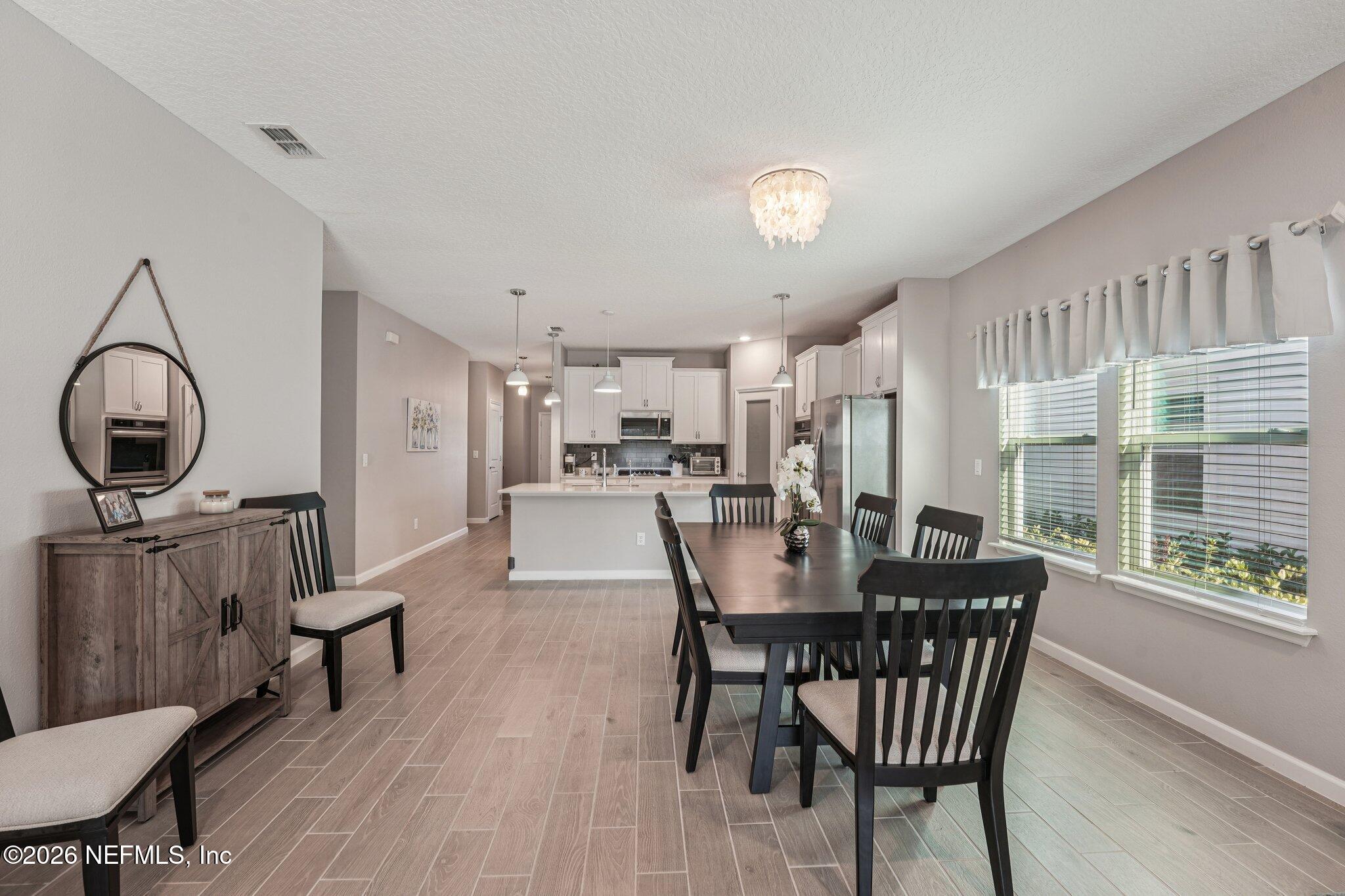 75682 Pondside Lane Yulee, FL 32097 - Photo 8 of 35 a view of a dining room with furniture window and wooden floor