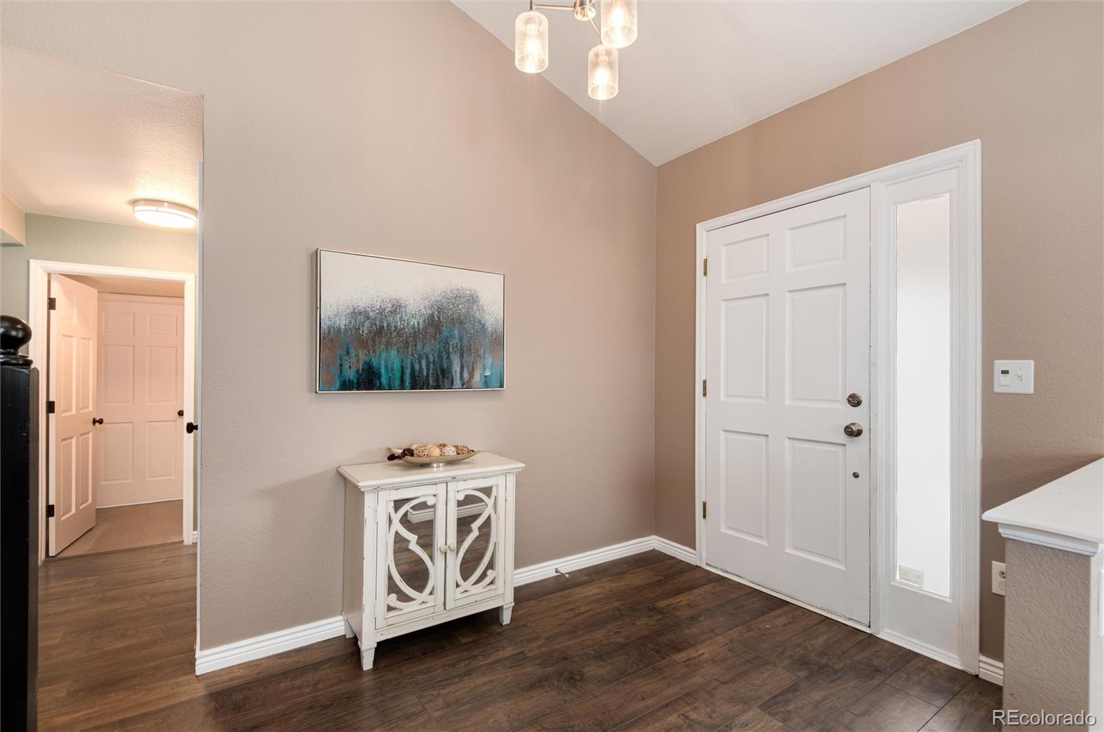 9866 Spring Hill Lane Highlands Ranch, CO 80129 - Photo 3 of 49 a view of a livingroom with wooden floor and entryway