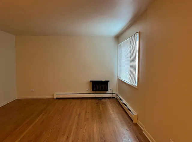 a view of a room with wooden floor and a window
