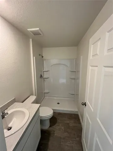 a bathroom with a granite countertop sink toilet and shower