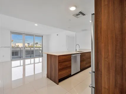 a room with stainless steel appliances wooden floor and chandelier