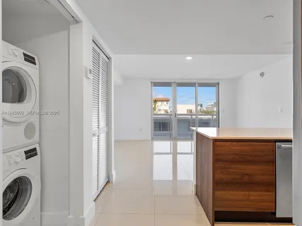 a view of kitchen with refrigerator sink and cabinets