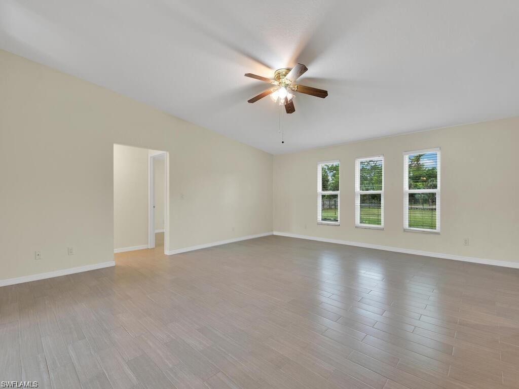 260 12th Street Southeast Naples, FL 34117 - Photo 11 of 29 a view of an empty room with chandelier fan and wooden floor