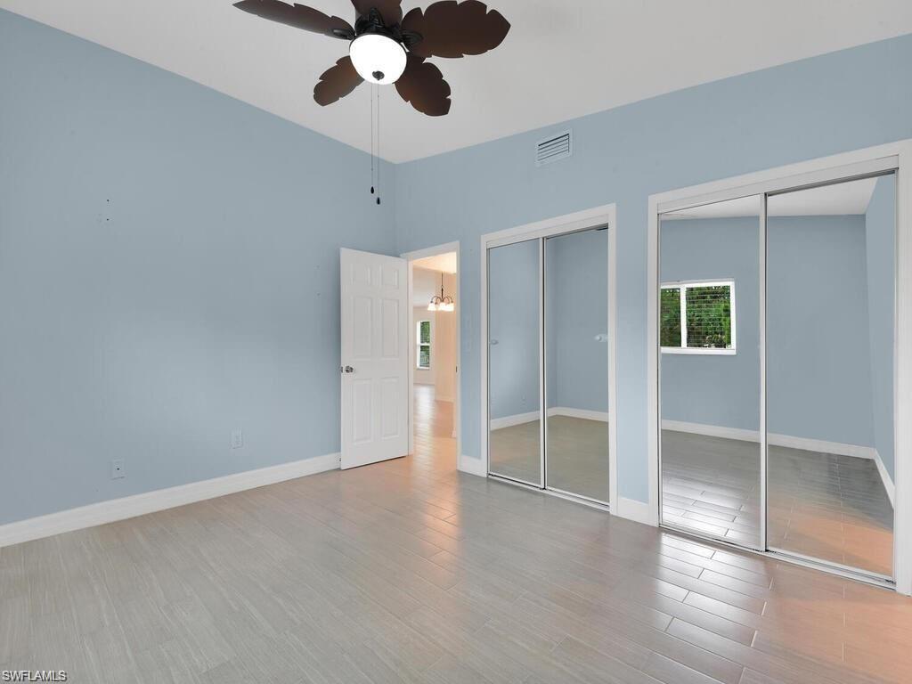 260 12th Street Southeast Naples, FL 34117 - Photo 17 of 29 an empty room with wooden floor cabinet and windows