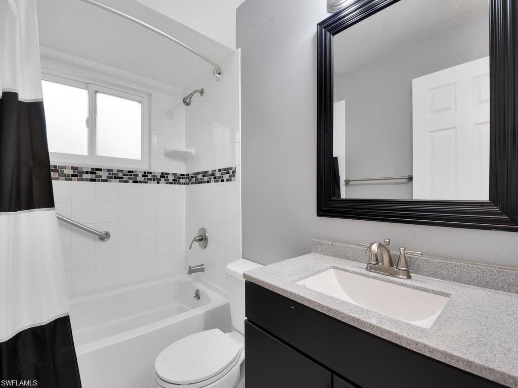 260 12th Street Southeast Naples, FL 34117 - Photo 19 of 29 a bathroom with a granite countertop sink mirror toilet and bathtub