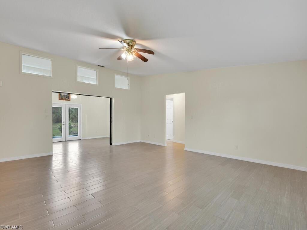 260 12th Street Southeast Naples, FL 34117 - Photo 6 of 29 a view of an empty room with wooden floor and a ceiling fan