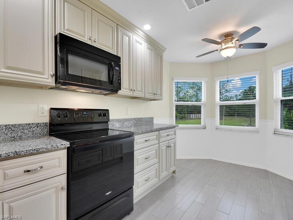 260 12th Street Southeast Naples, FL 34117 - Photo 8 of 29 a kitchen with cabinets stainless steel appliances a sink and a microwave