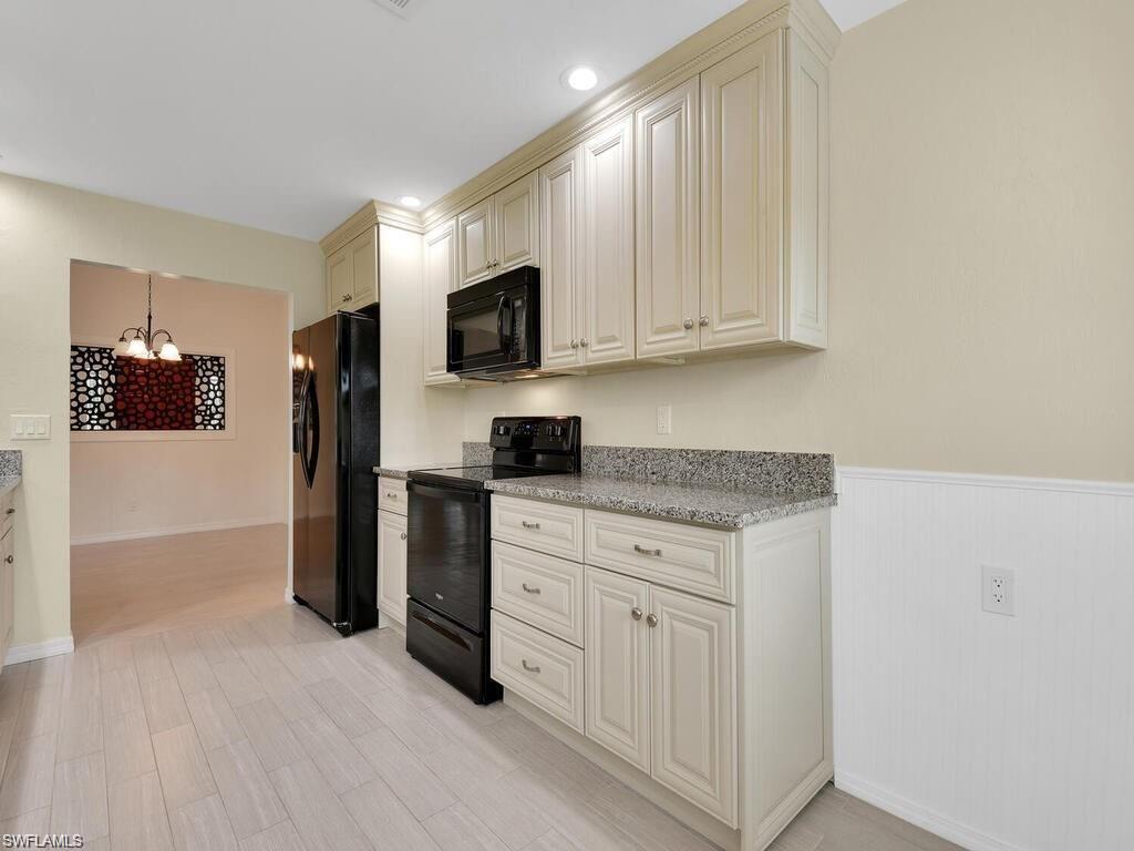 260 12th Street Southeast Naples, FL 34117 - Photo 9 of 29 a kitchen with white cabinets and stainless steel appliances