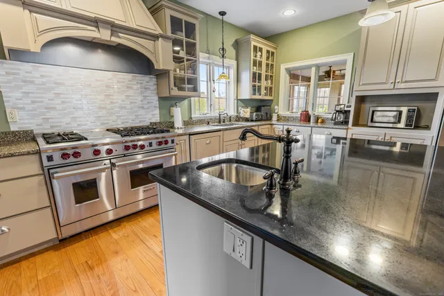 a kitchen with stainless steel appliances granite countertop a sink stove and cabinets