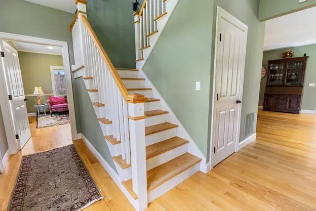 a view of a hallway with wooden floor and stairs