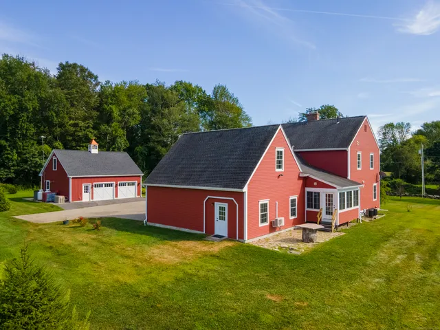 a front view of house with yard and trees in the background