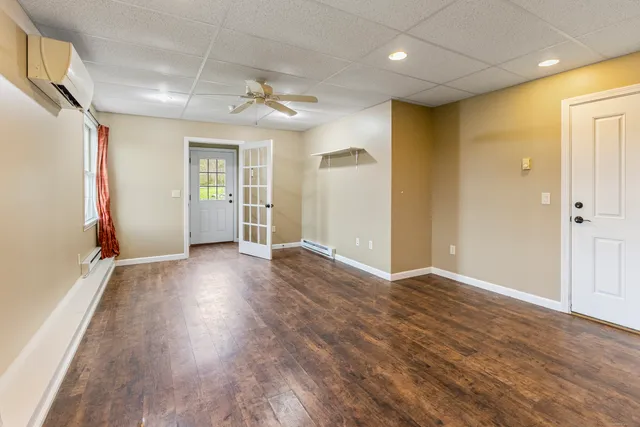 an empty room with wooden floor and a ceiling fan