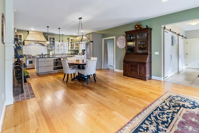 a living room with stainless steel appliances kitchen island furniture and a table