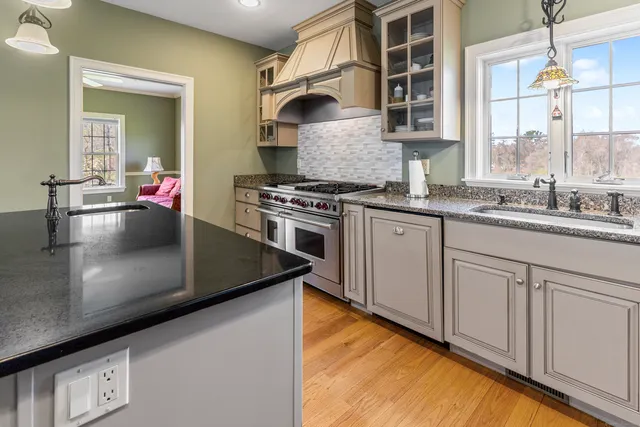 a kitchen with stainless steel appliances granite countertop a sink stove and cabinets