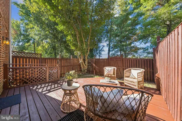 a view of a patio with table and chairs with wooden floor and fence