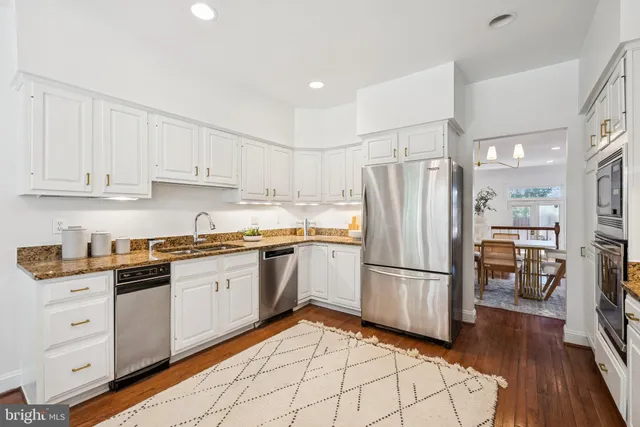 a kitchen with granite countertop stainless steel appliances a refrigerator a stove top oven and a refrigerator