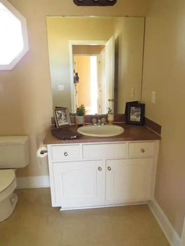 a bathroom with a granite countertop toilet sink and mirror