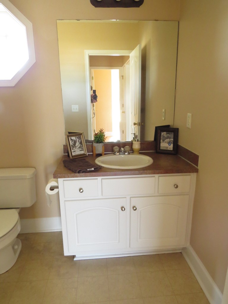 2 Whippoorwill Lane Fort Mitchell, AL 36856 - Photo 17 of 27 a bathroom with a granite countertop toilet sink and mirror