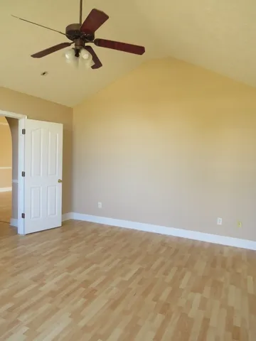 a view of room with a ceiling fan and wooden floor
