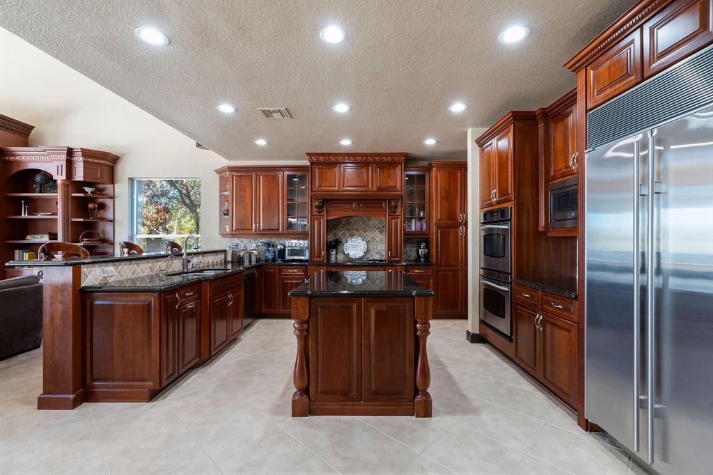 3413 Dovecote Meadow Lane Davie, FL 33328 - Photo 19 of 68 a kitchen with stainless steel appliances granite countertop a refrigerator a sink and a stove