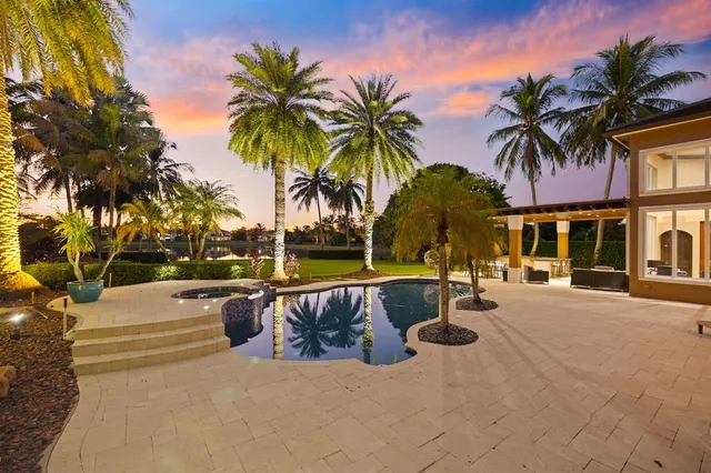 a row of palm trees and swimming pool in the backyard of a house