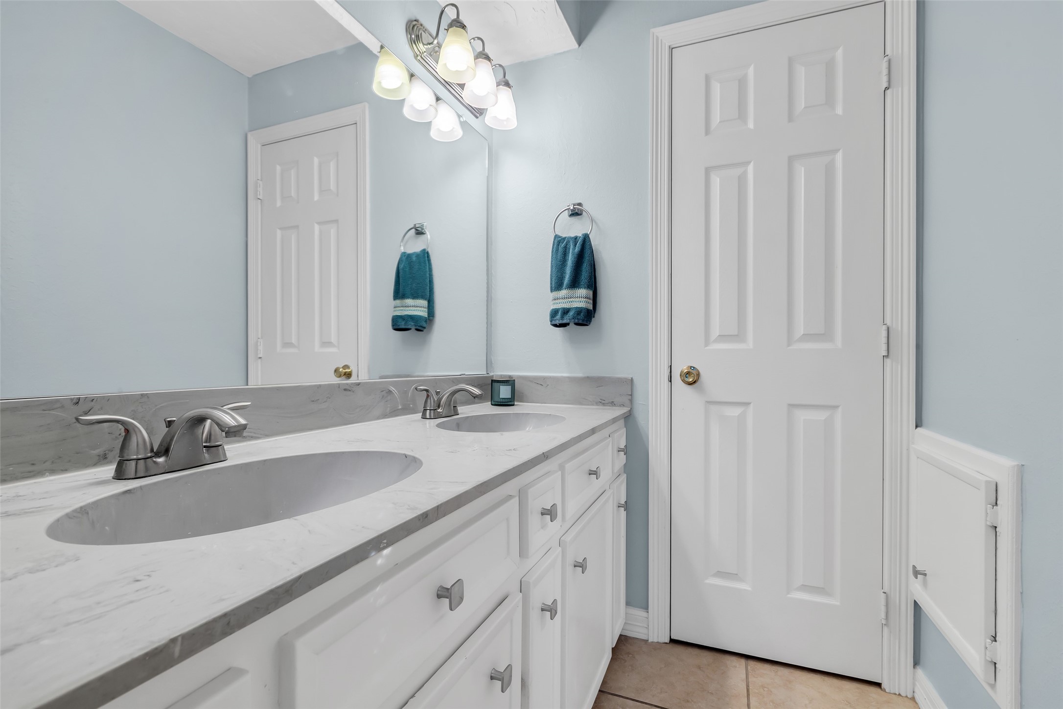 24102 Northcrest Drive Spring, TX 77389 - Photo 14 of 31 This inviting upstairs bath features a chic double vanity. Complemented by soft blue walls and modern lighting for a serene, spa-like atmosphere.