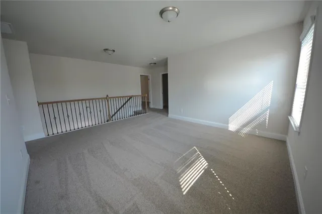 en empty room with windows and a ceiling fan