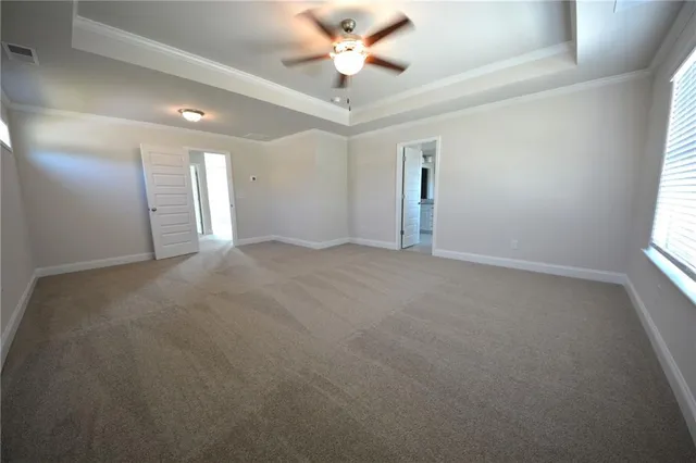an empty room with windows and ceiling fan