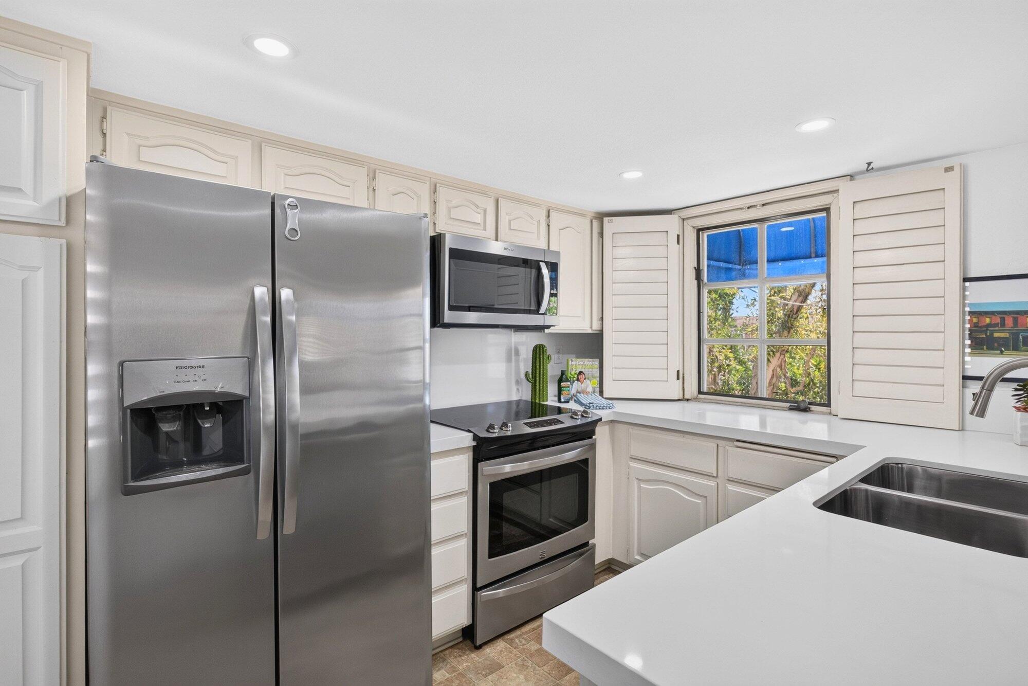 500 East Amado Road, Unit 313 Palm Springs, CA 92262 - Photo 6 of 32 a kitchen with a refrigerator and a sink