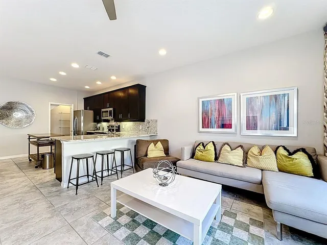 a living room with furniture kitchen view and a flat screen tv