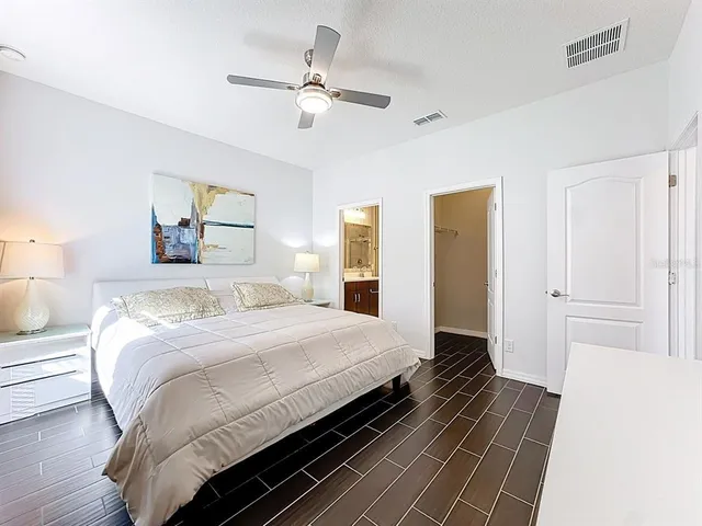 a bedroom with a bed and wooden floor