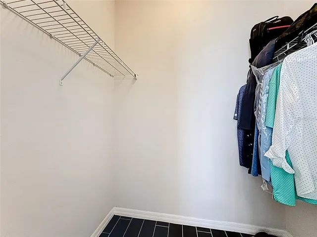 a view of walk in closet with clothes and shoes