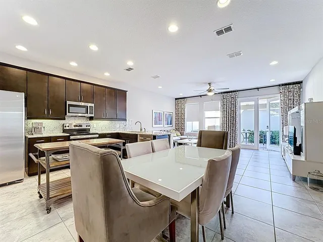 a large kitchen with kitchen island a large window cabinets and stainless steel appliances