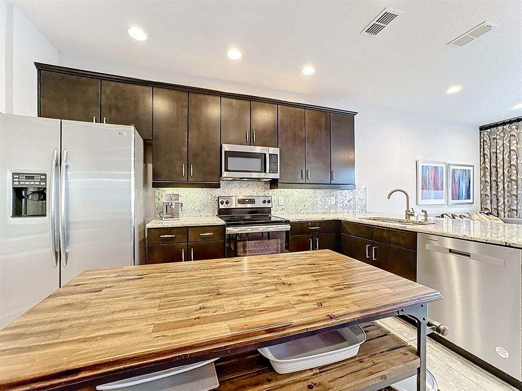 11209 Grander Drive Windermere, FL 34786 - Photo 6 of 35 a kitchen with kitchen island a counter space a sink appliances and cabinets