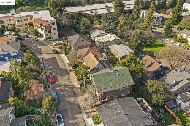 an aerial view of a house with a yard and mountain view in back