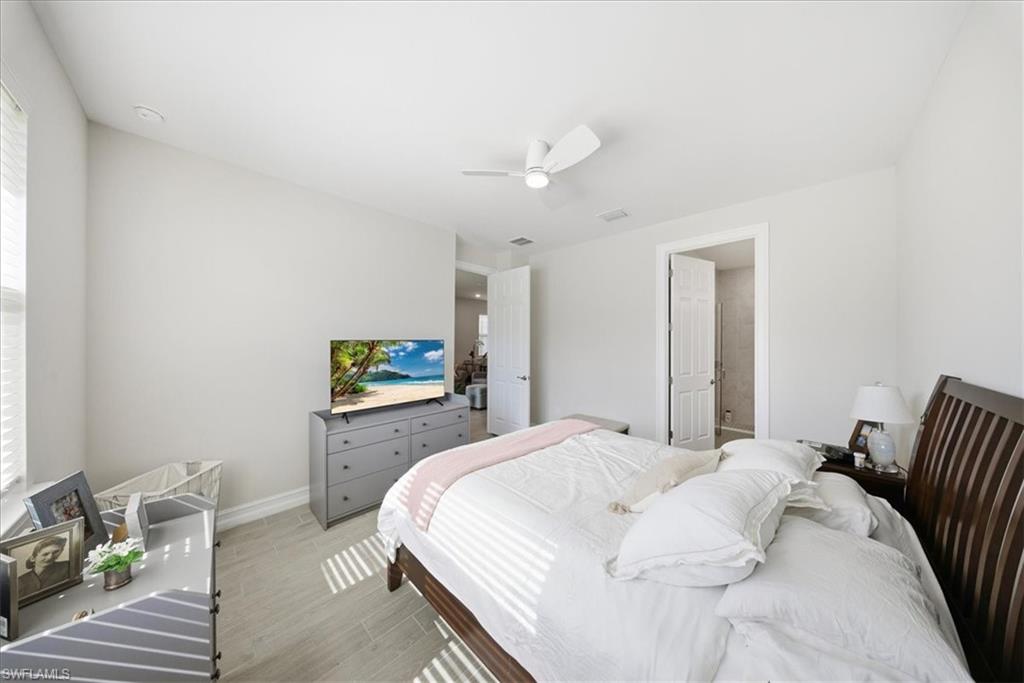 1074 Enbrook Loop Naples, FL 34114 - Photo 18 of 36 a bedroom with a bed and a painting on the wall