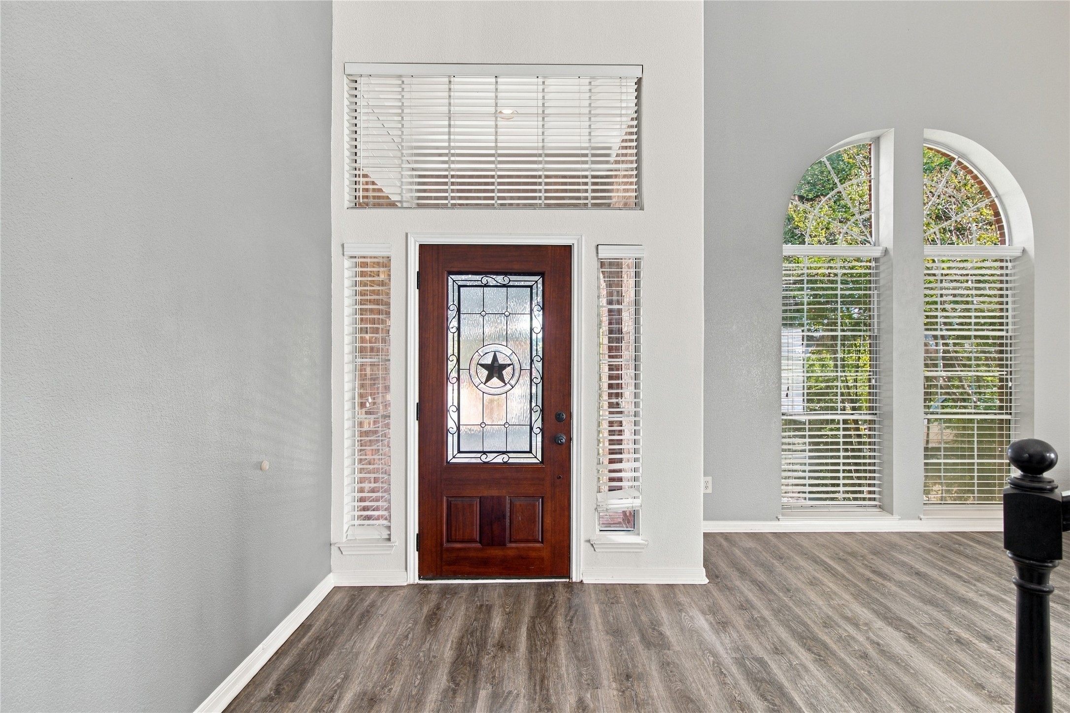 910 Point Run Drive Pflugerville, TX 78660 - Photo 9 of 39 An inviting entryway welcomes guests with towering ceilings, arched windows, and durable wood-look flooring.