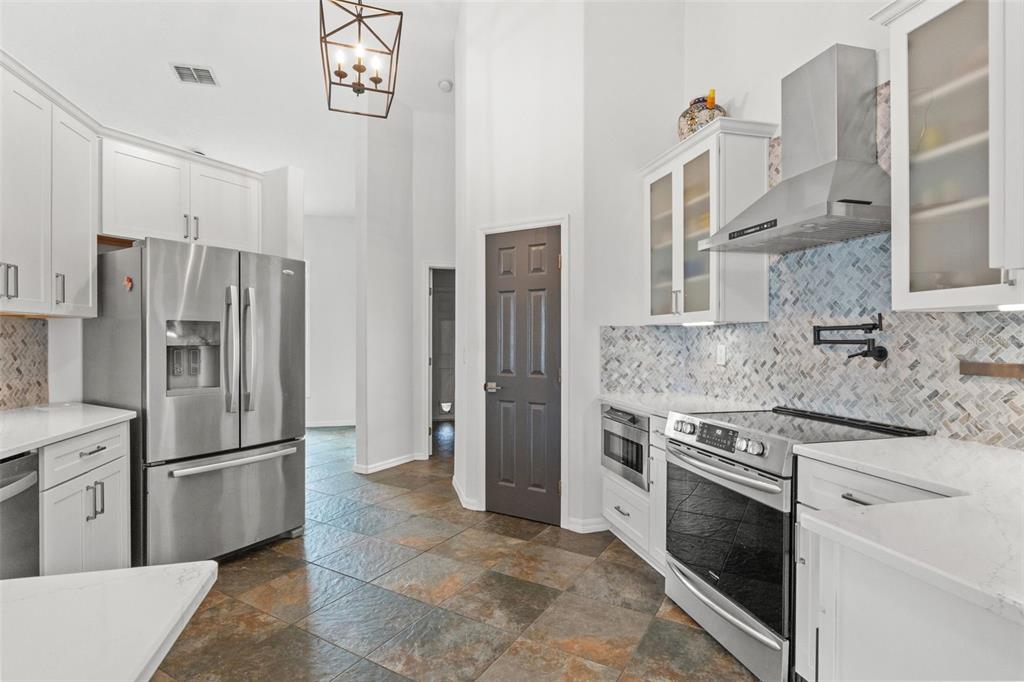 3456 Hanging Moss Loop Spring Hill, FL 34609 - Photo 21 of 81 a kitchen with stainless steel appliances granite countertop a sink stove and refrigerator