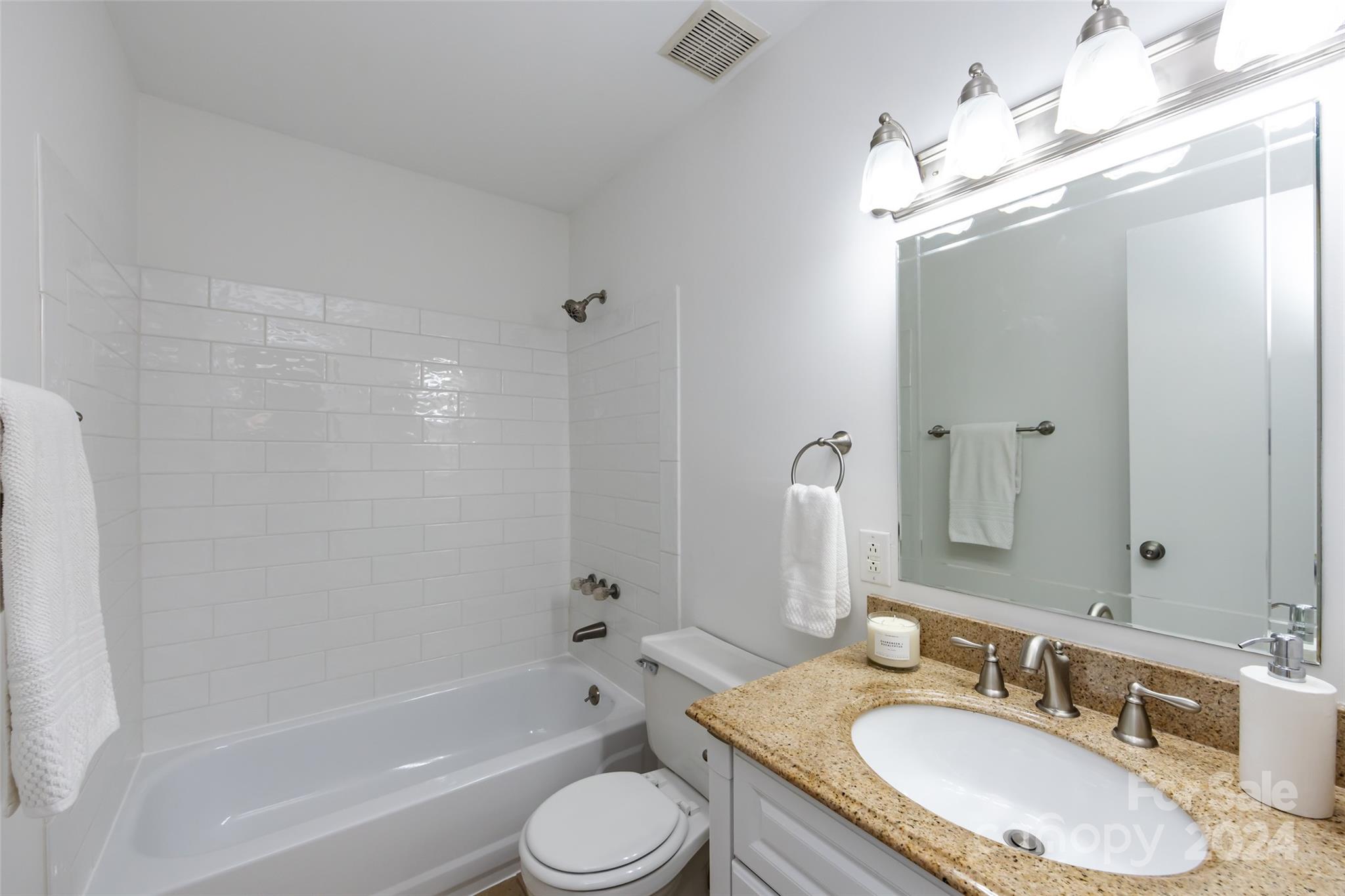 430 Queens Road, Unit 231 Charlotte, NC 28207 - Photo 17 of 23 a bathroom with a granite countertop sink shower bathtub and a mirror